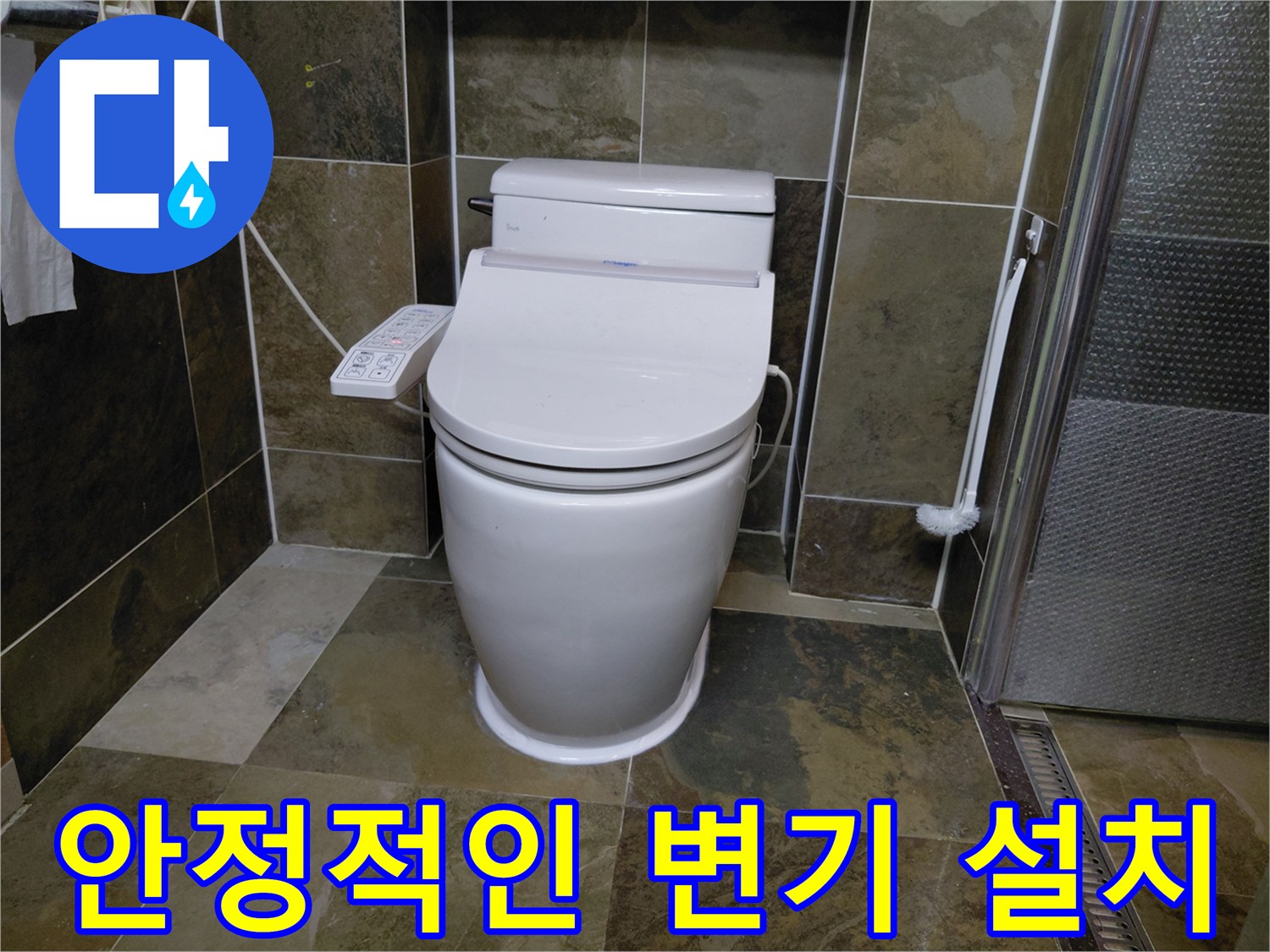 화장실 바닥 타일 위에 안정적으로 안착된 양변기와 컨트롤러 모습