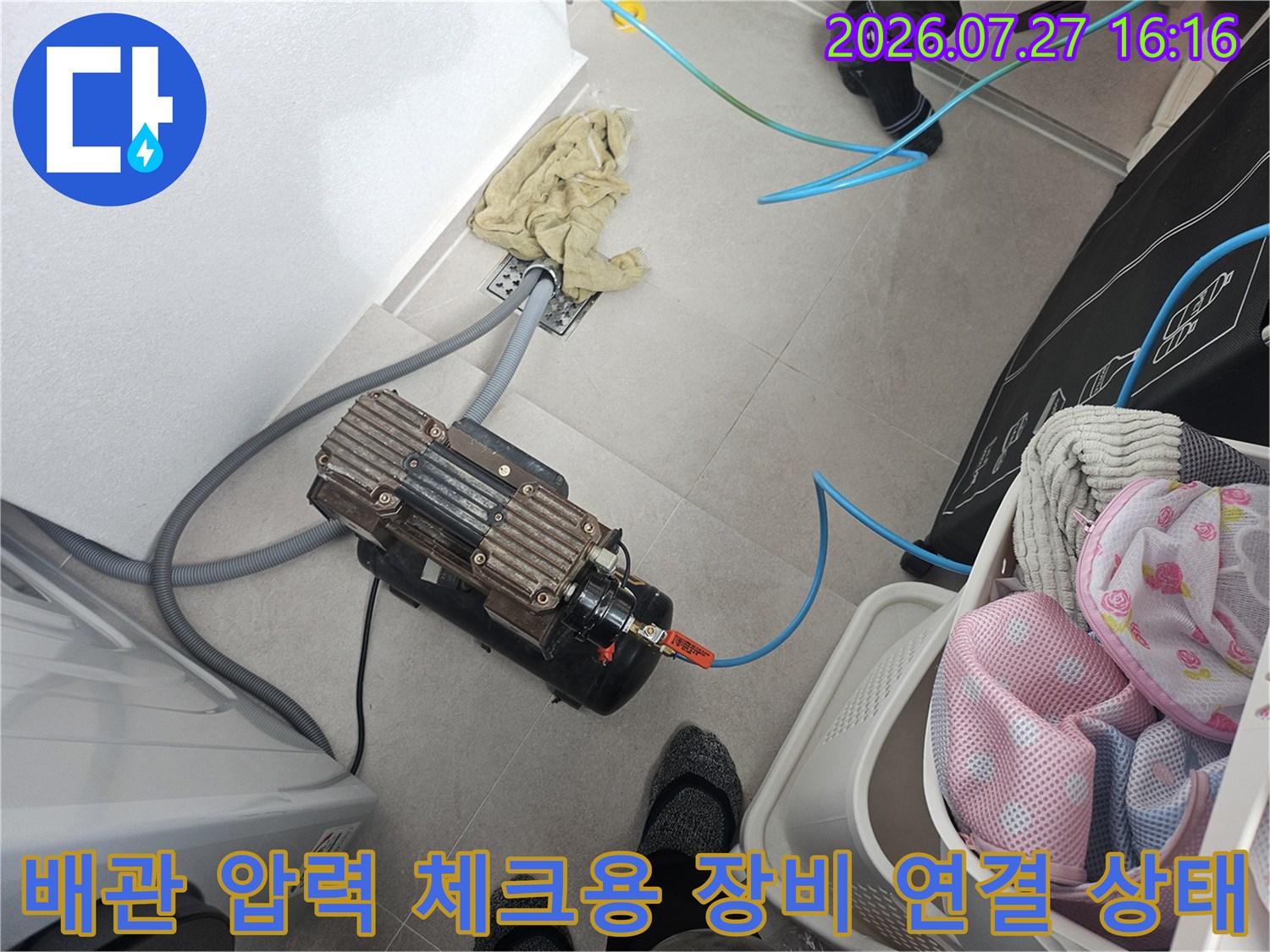 회색 주름관과 파란색 호스가 연결된 공기압 측정 장비-바닥 거치 모습