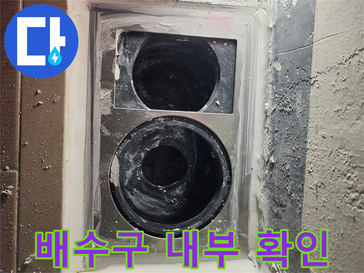 세탁실 배수구 주변의 파손된 방수층과 노출된 배관 상태