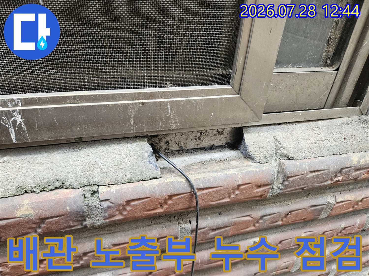 노출된 배관과 파손된 콘크리트 주변을 정밀하게 진찰하는 장면