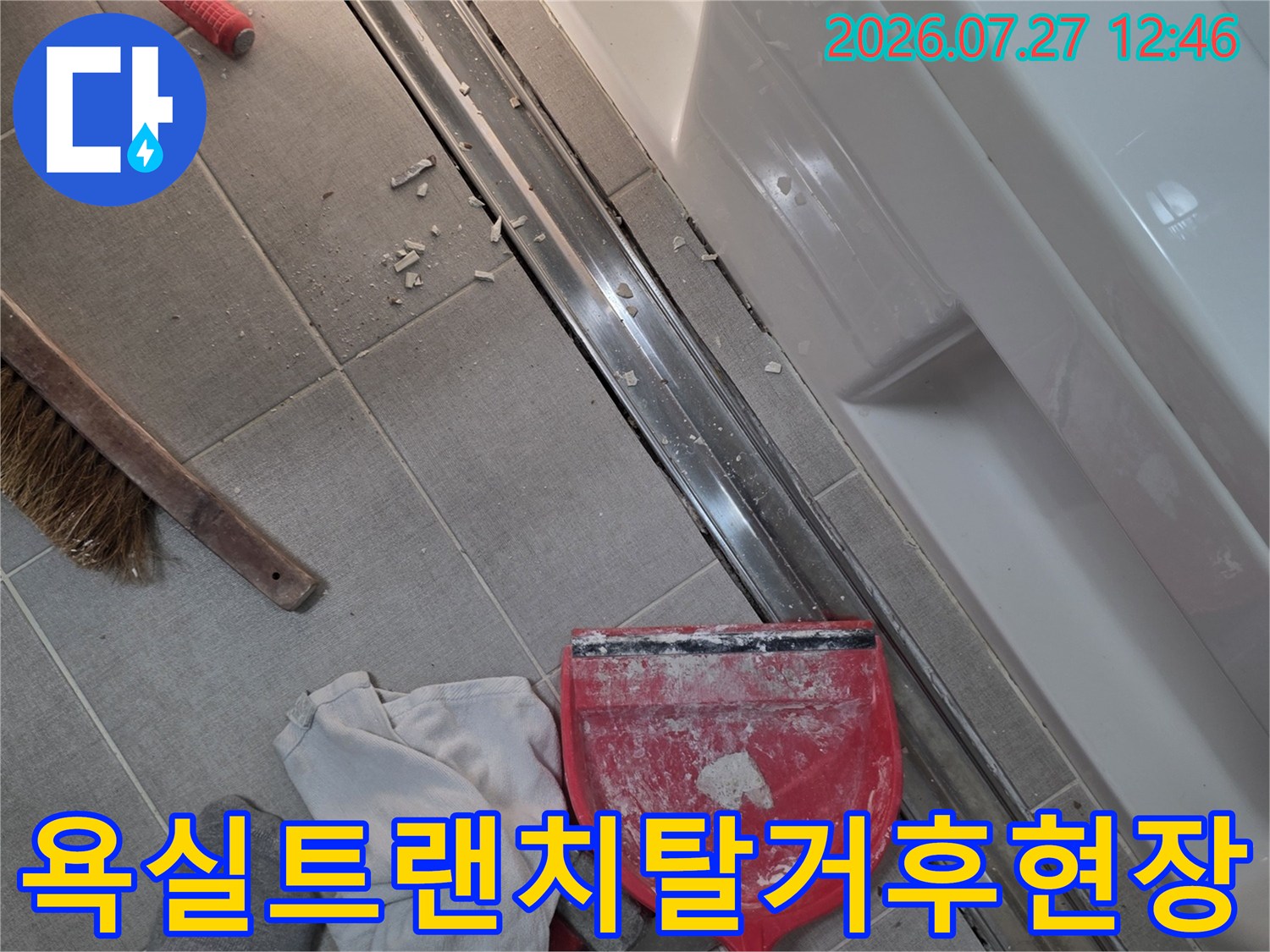 욕실-바닥의-긴-배수구-트랜치가-제거되고-주변에-먼지와-공구가-놓여있는-모습