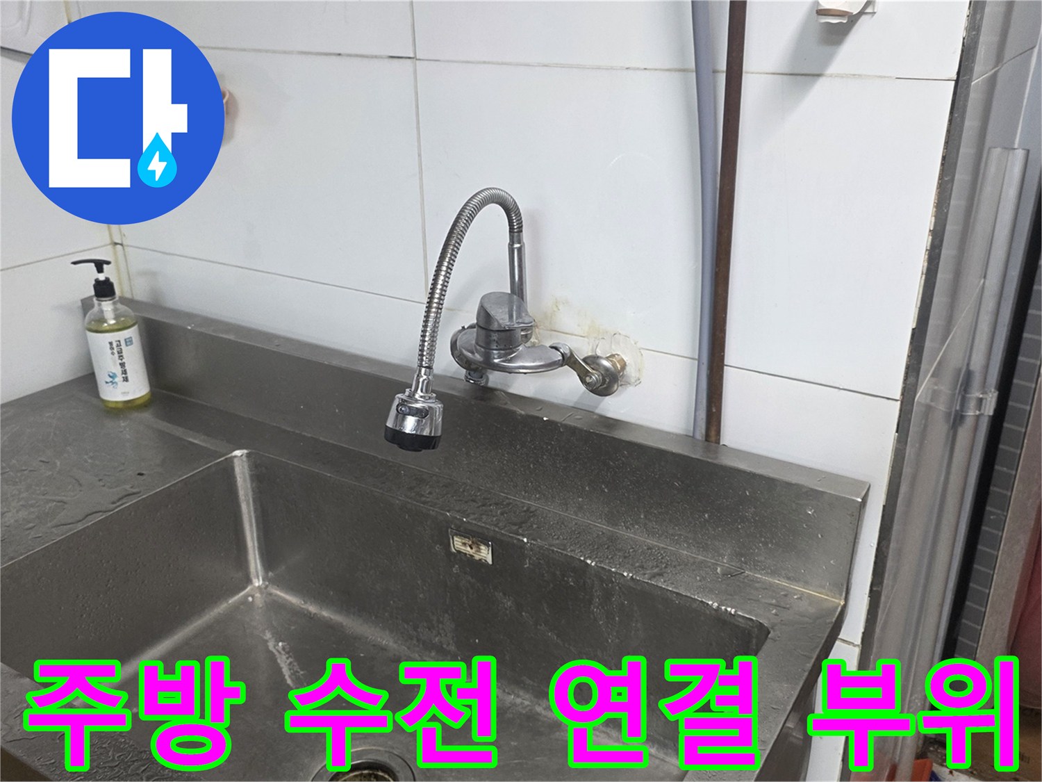 스테인리스 싱크대와 벽면에 설치된 수전의 연결 상태를 보여줍니다.