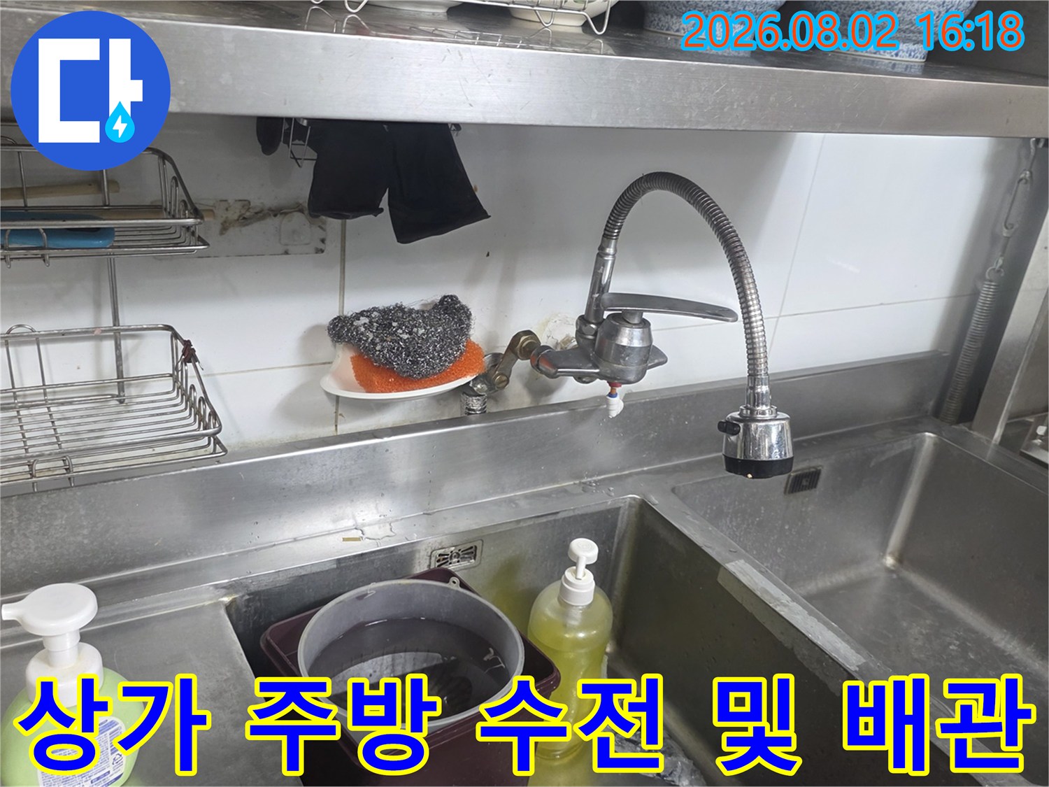 싱크대 밑에 위치한 은색 수전과 연결된 수도관체계