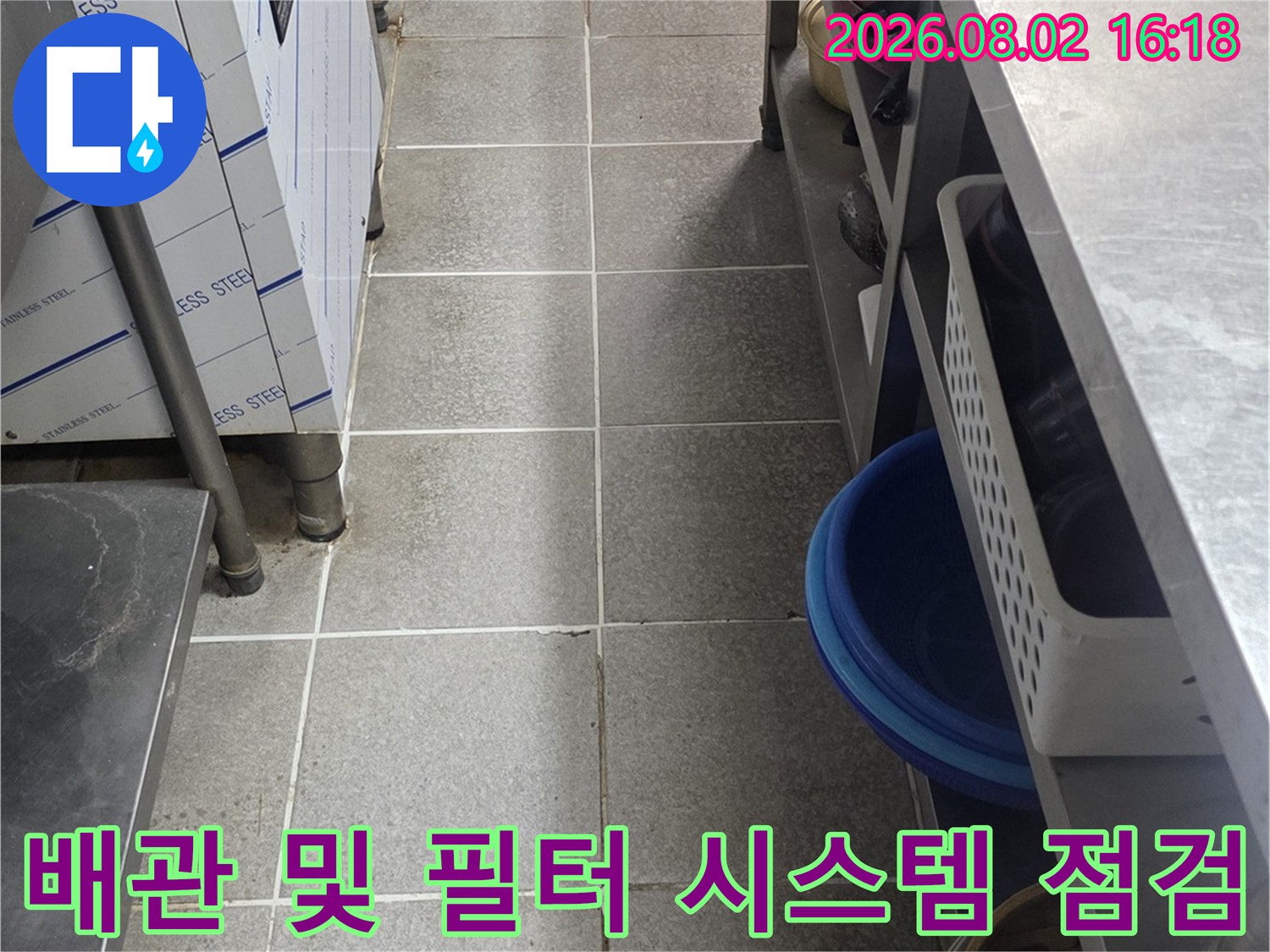 주방 싱크대 하부의 복잡한 배관망과 정수 여과 장치들