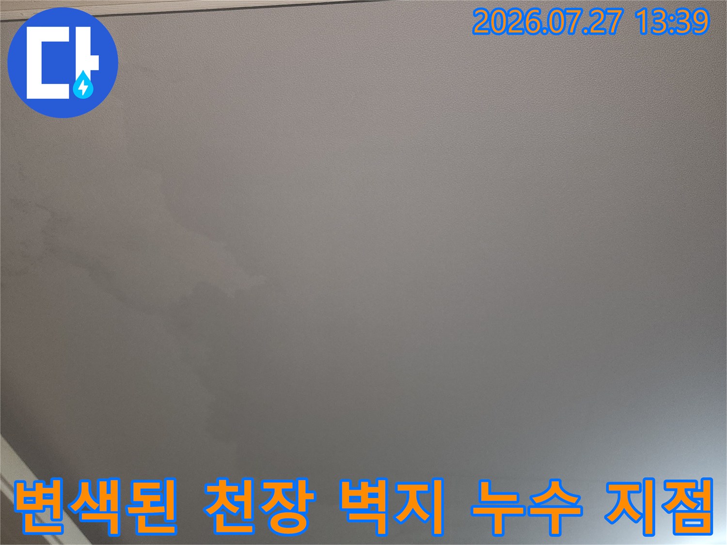 거실 천장의 흰색 도배지가 물에 젖어 노랗고 어둡게 변한 모습