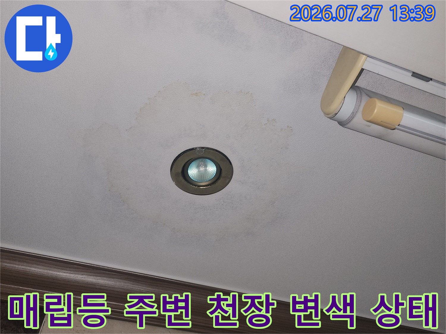 누수로 인해 거실 천장의 도배지가 변색되어 얼룩진 모습-사진
