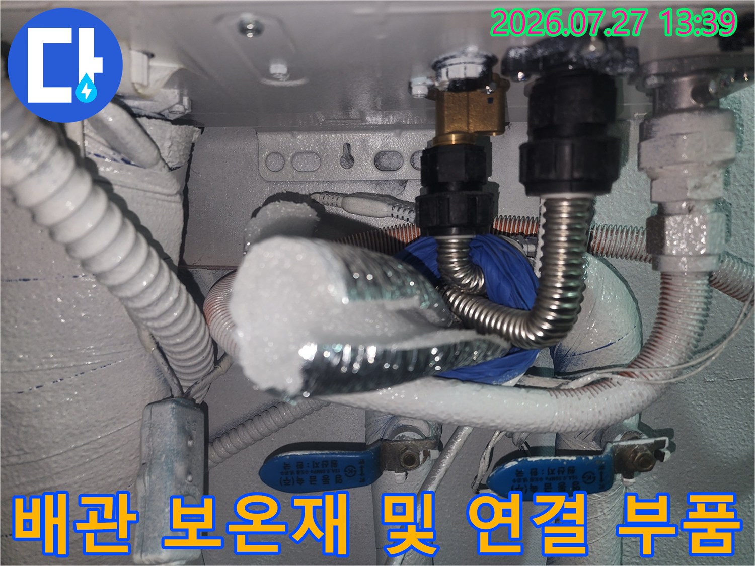 흰색 보온 단열재와 금속제 주름 배관이 얽혀 있는-보일러 하단부 상세 사진