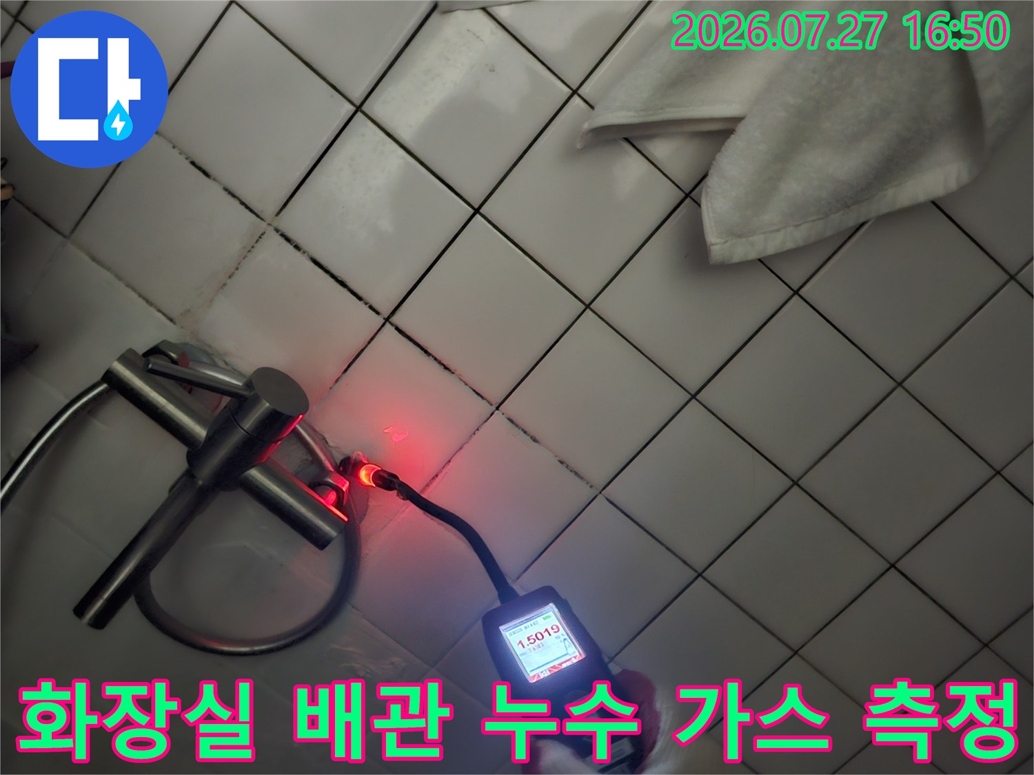 작업자가 장갑을 착용하고 배관 연결 부위에서 가스 탐지기로 수치를 체크하는 모습