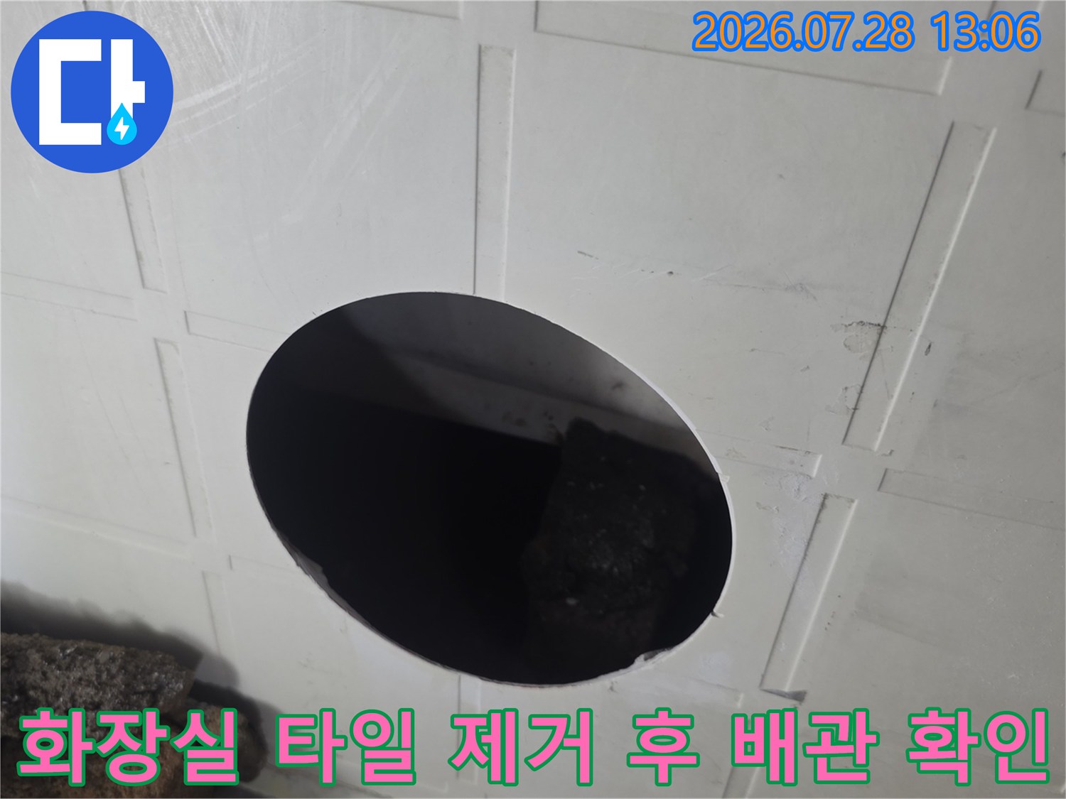 타일이 제거된 공간에 노출된 배관과 내부 구조를 점검하는 장면