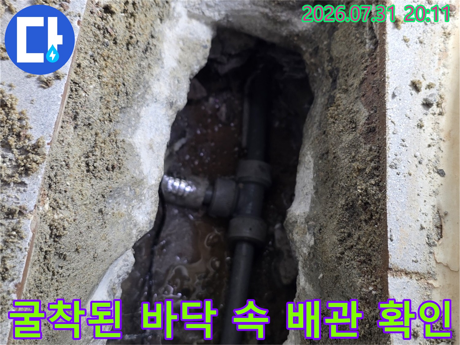 노출된 파손 배관과 주변의 젖은 콘크리트 상태