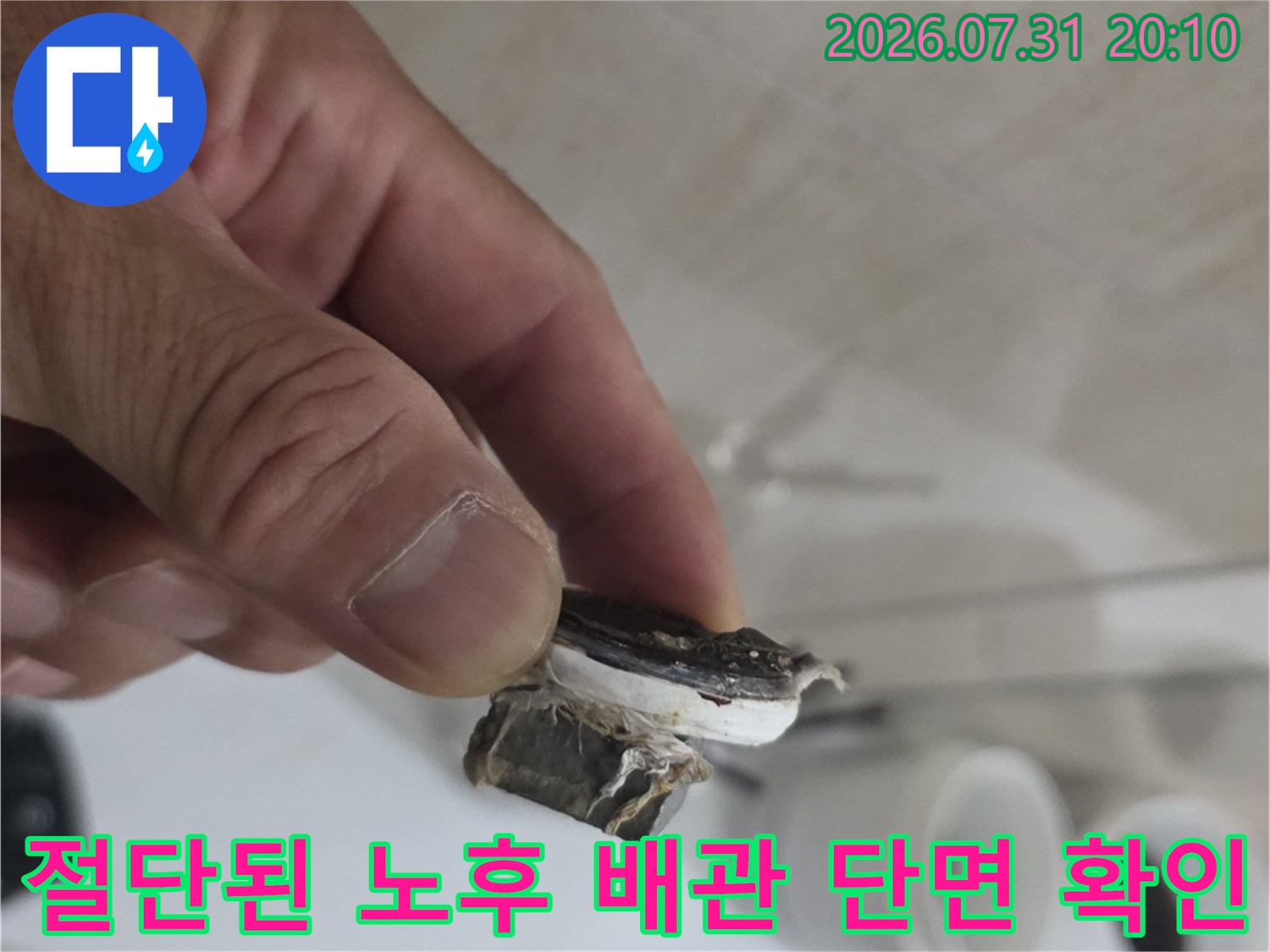 손에 들린 파손된 직수 배관의 상세한 상태를 보여주는 사진