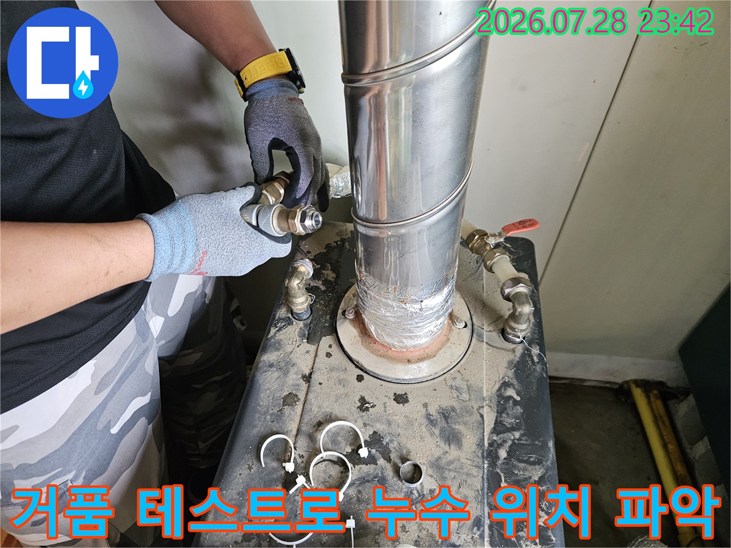 장갑을 낀 작업자가 거품을 사용하여 배관의 기밀성을 확인하는 모습