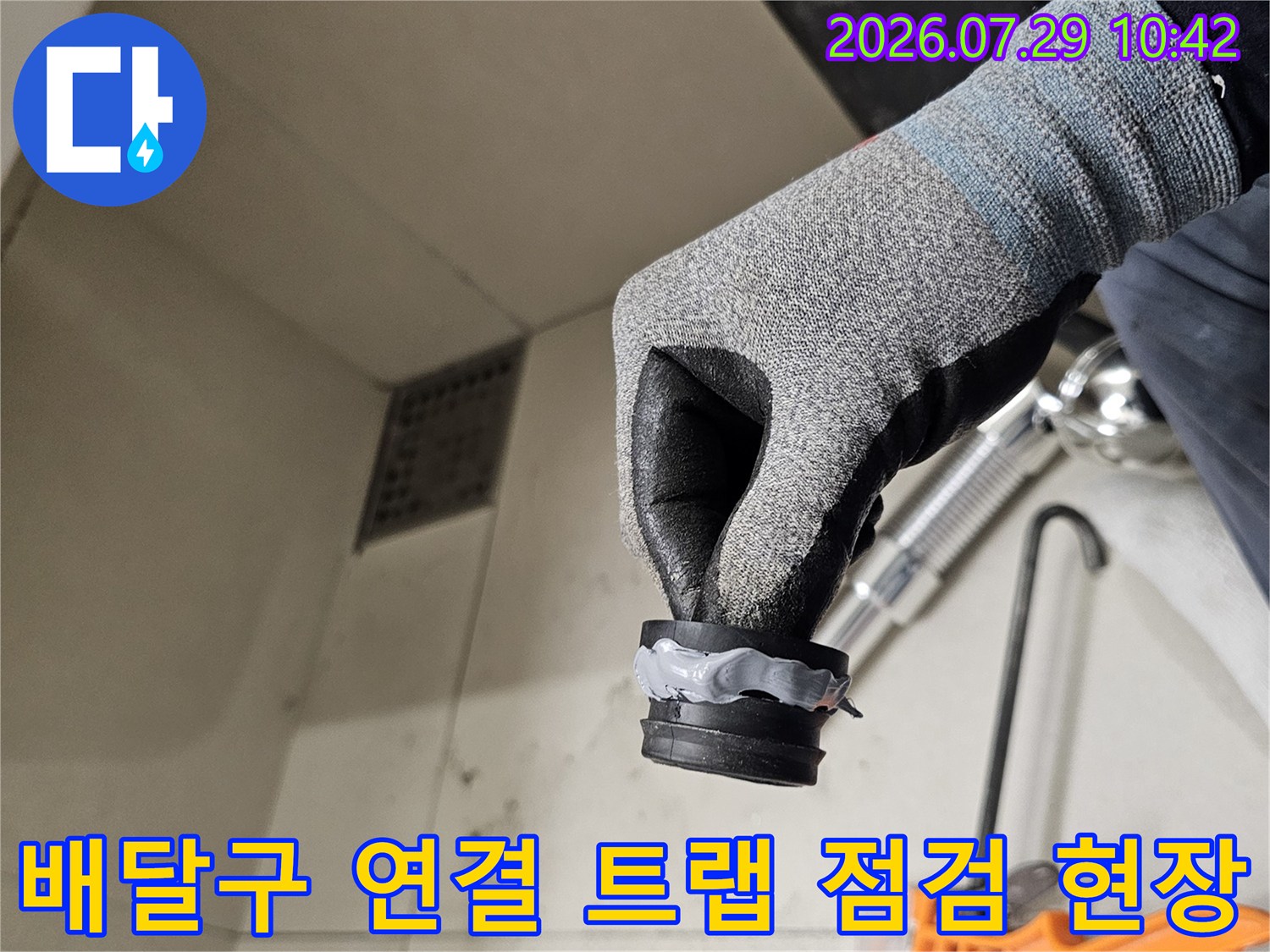 작업자가 세면대 하부의 노출된 배관과 트랩을 직접 만지며 누수 여부를 확인하는 과정