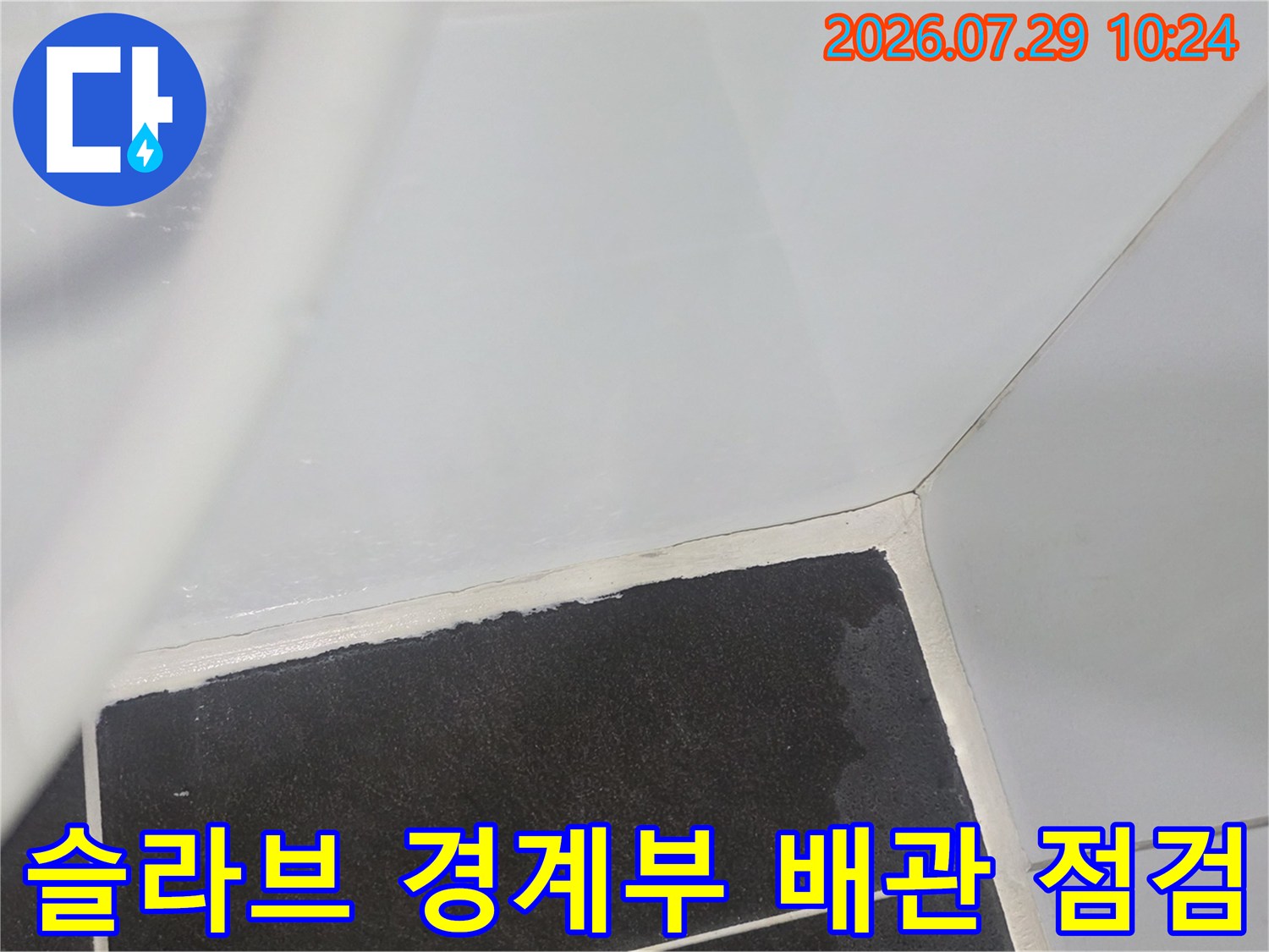 흰색 배관 주변의 어두운 천장 마감재와 접합 부위 상세 확인