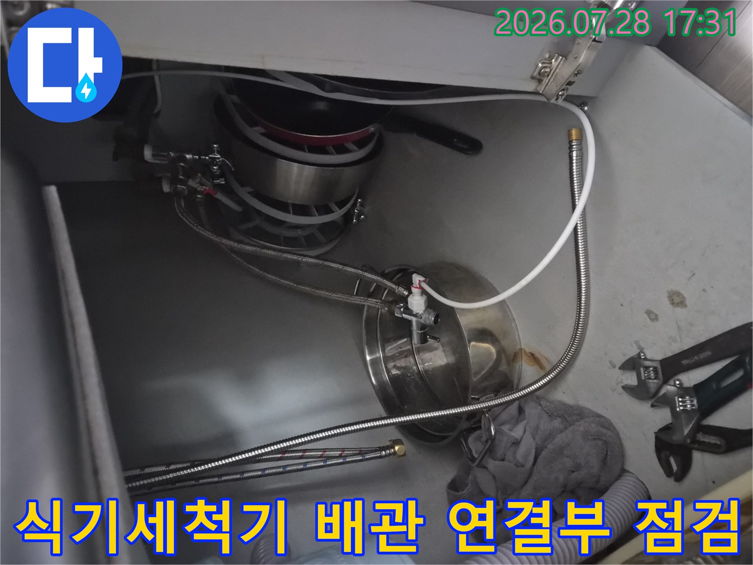 싱크대 아래 식기세척기용 수량 배관의 체결 상태를 확인하는 현장 사진
