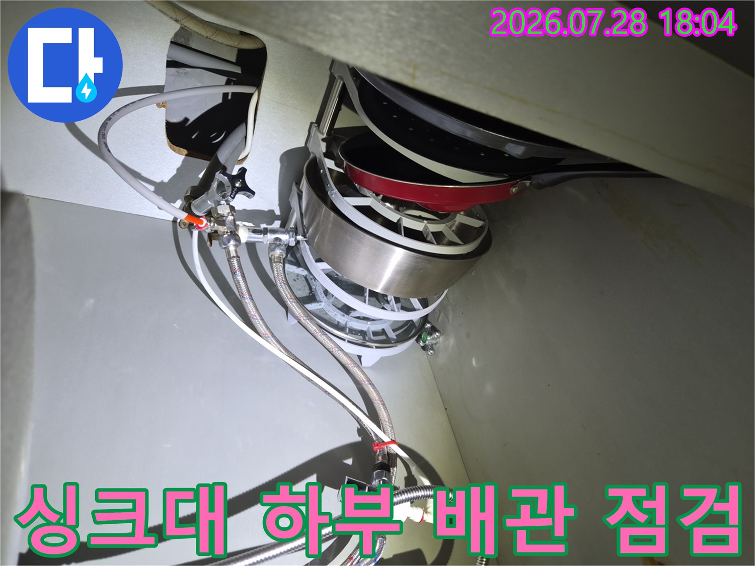 싱크대 하부장에서 식기세척기 연결 부위 배관을 점검하는 모습
