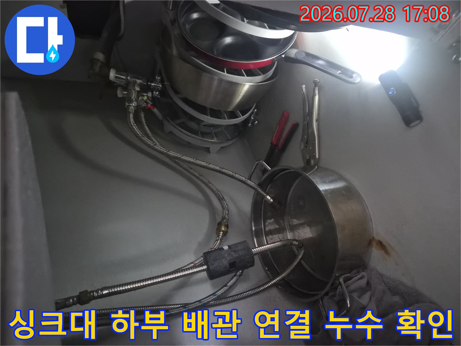 주방 싱크대 밑 식기세척기용 수전 배관의 결합 상태를 촬영한 사진