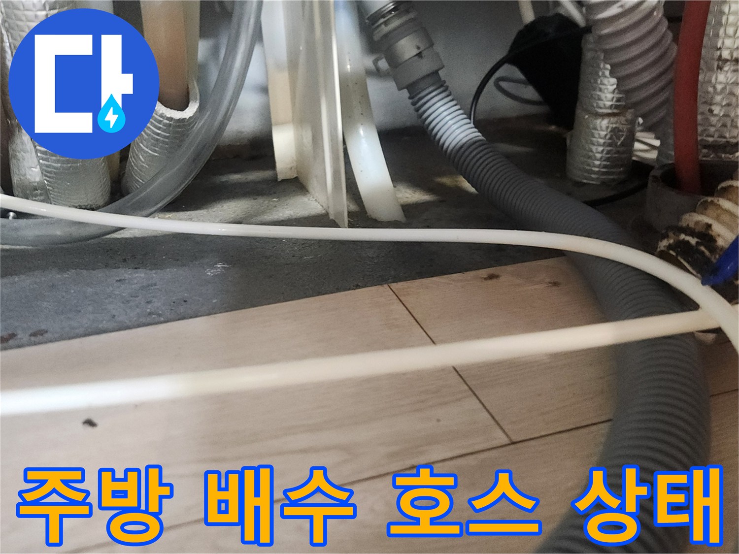복잡하게 얽힌 싱크대 하부 배수관과 유연한 주름관의 모습