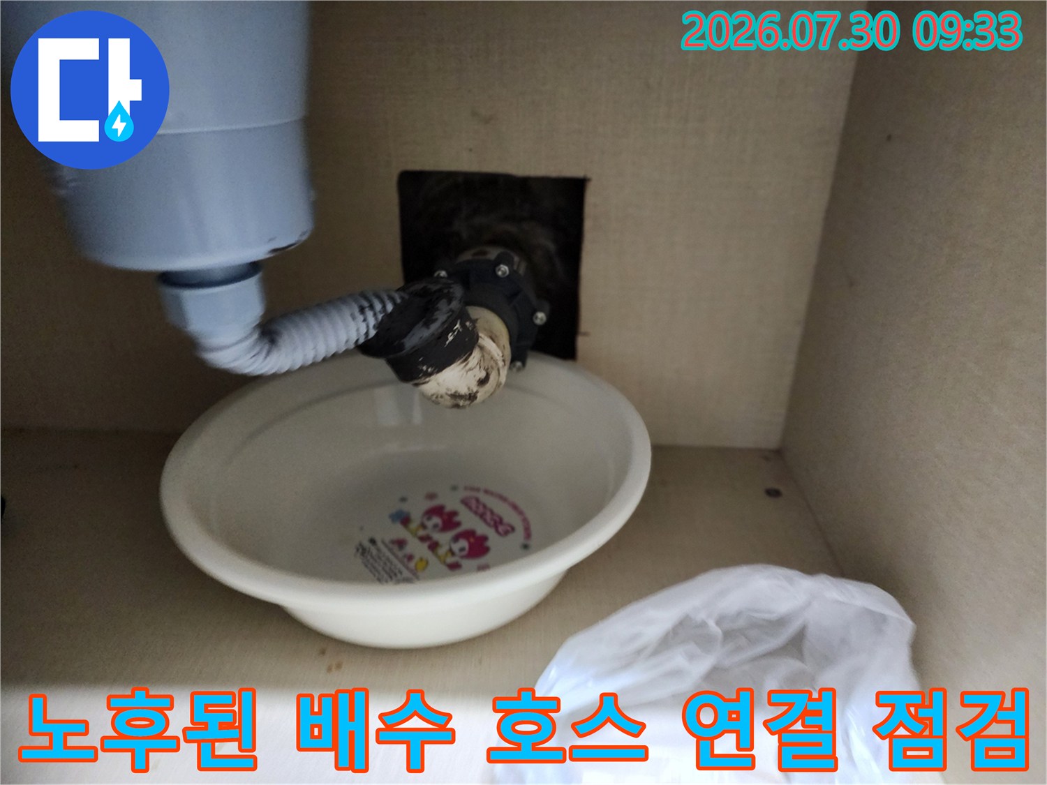 싱크대 아래 배출구 쪽으로 이어지는 호스의 마감 상태를 촬영한 이미지입니다.