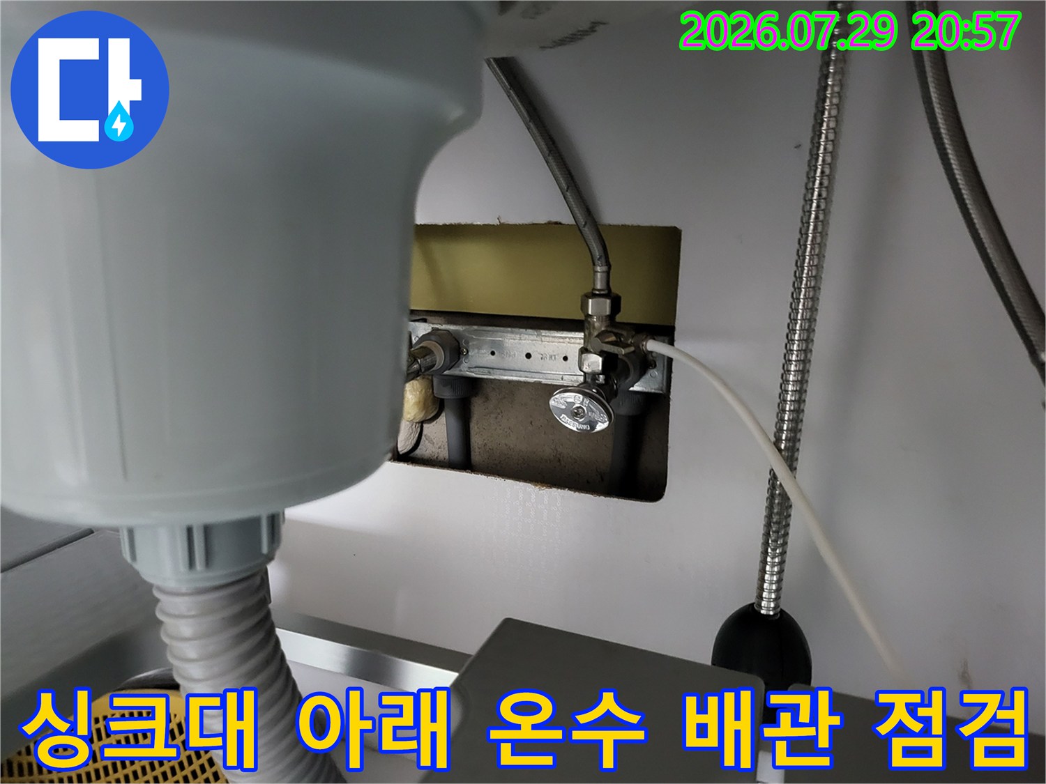 싱크대 하부 공간에 위치한 온수 배관과 연결 부위의 정밀 점검 모습