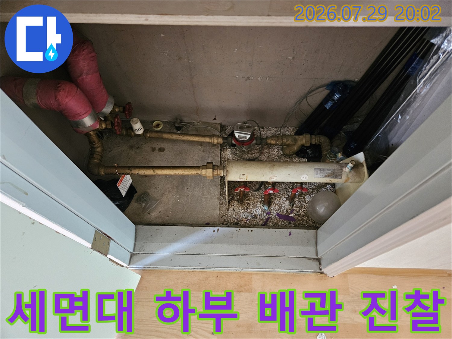 복잡하게 구성된 세면대 밑 수도 배관의 연결 상태를 면밀히 점검하는 과정