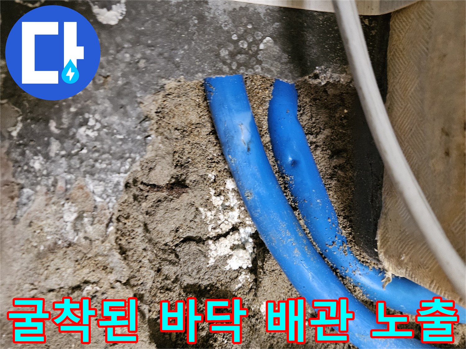 콘크리트 층을 제거하여 드러난 파란색 매립 배관