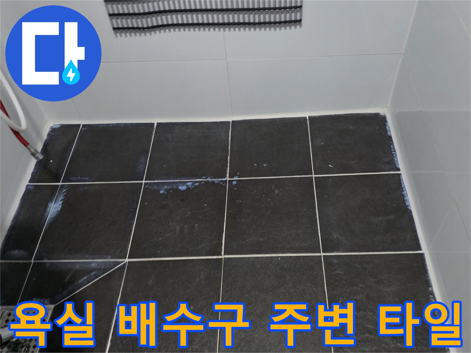 어두운 톤의 사각 타일과 하수구 유가