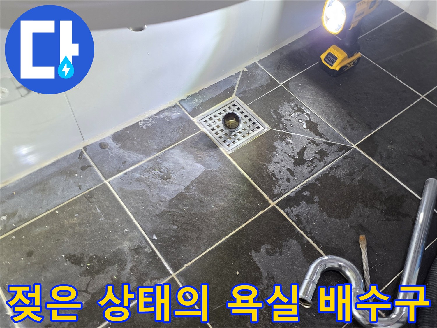 조명 아래 드러난 - 습기가 가득한 하수구 유가 주변 타일