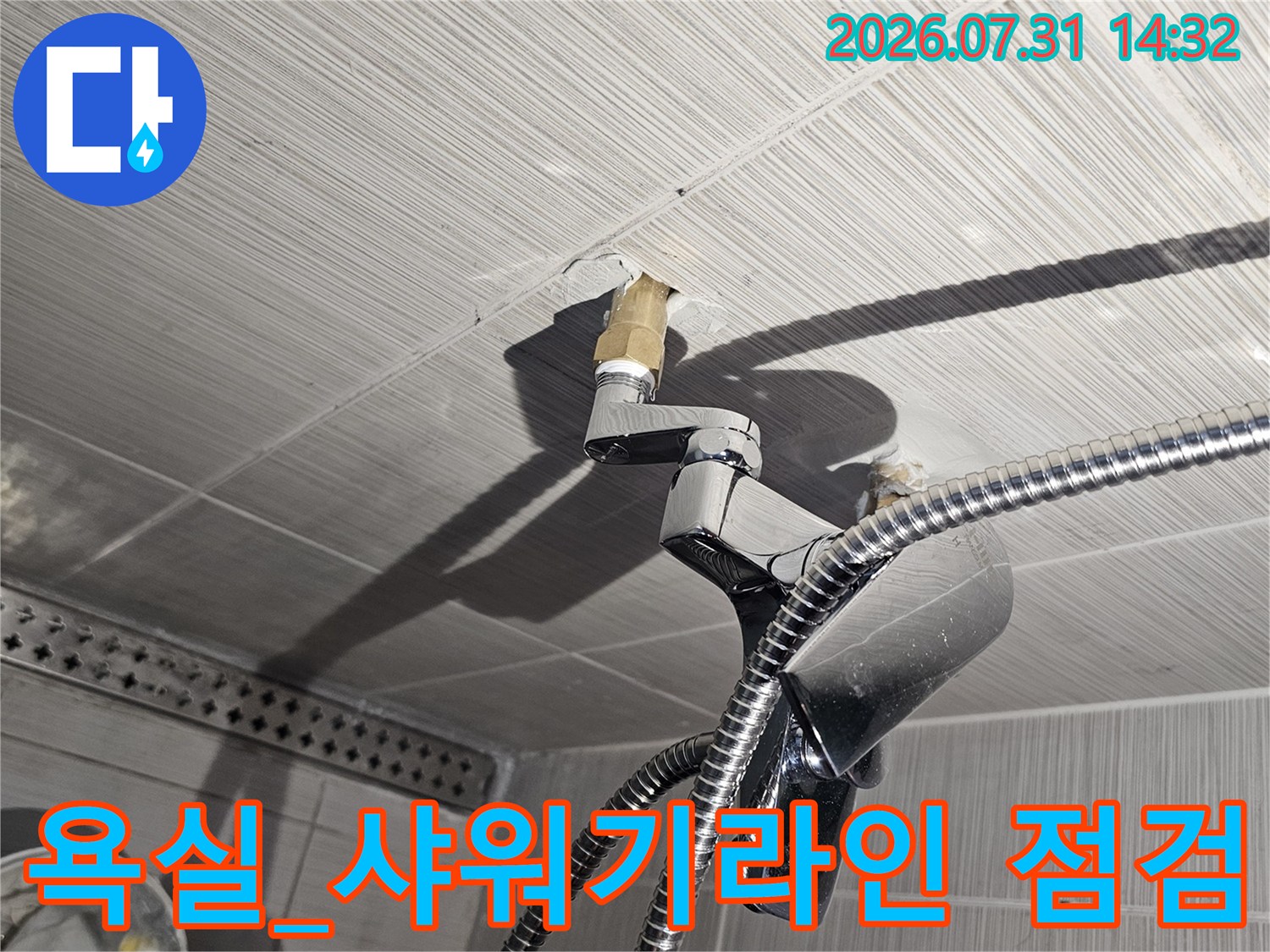 타일벽면을 관통하는 금속 배관과 샤워호스 연결부 촬영