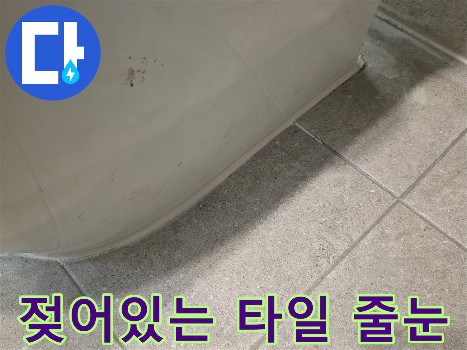 변기 하부 주변-습기로 인해 어둡게 오염된 타일 표면