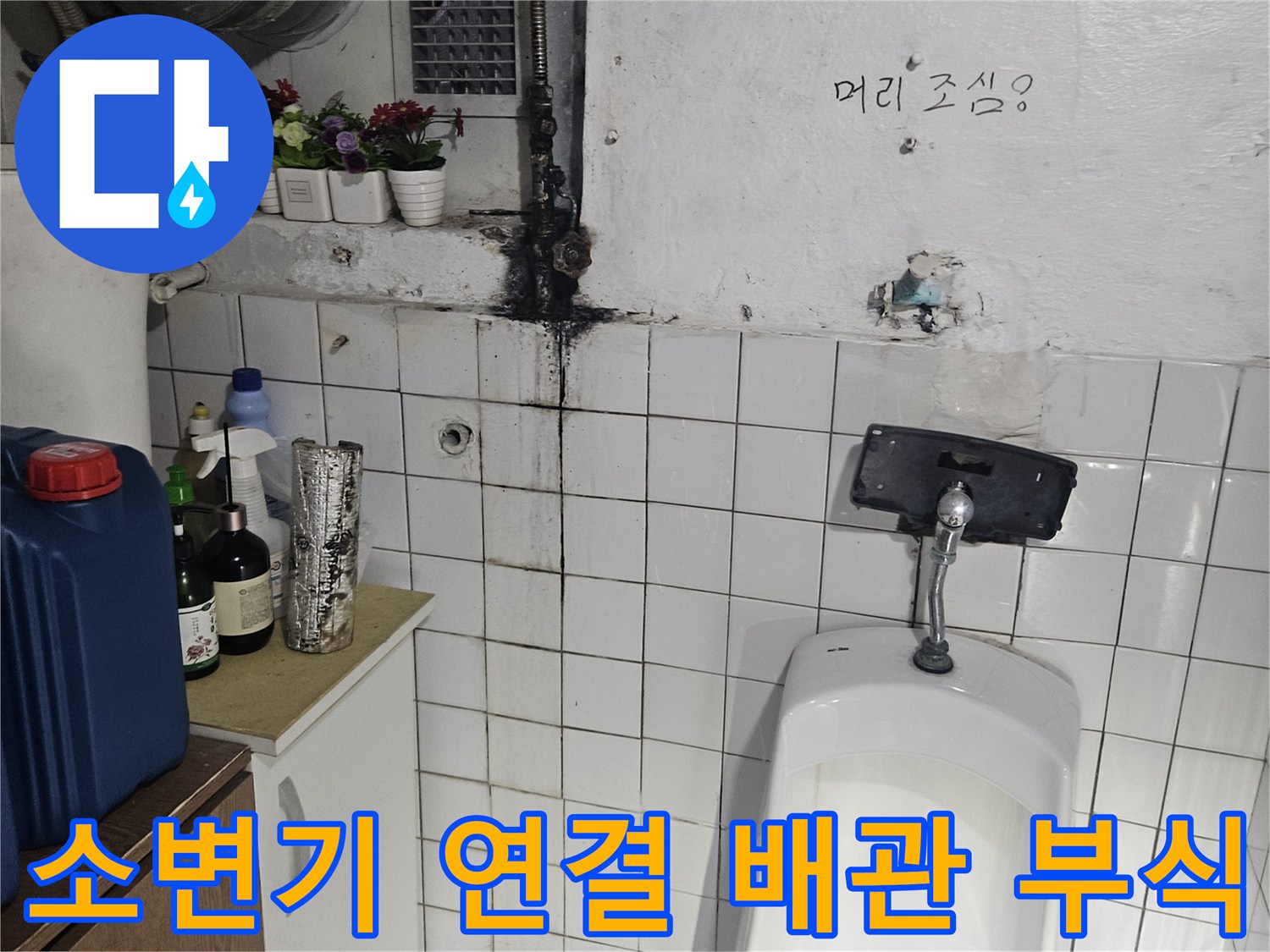 부식된 소변기 연결 배관과 오염된 타일 벽면 모습