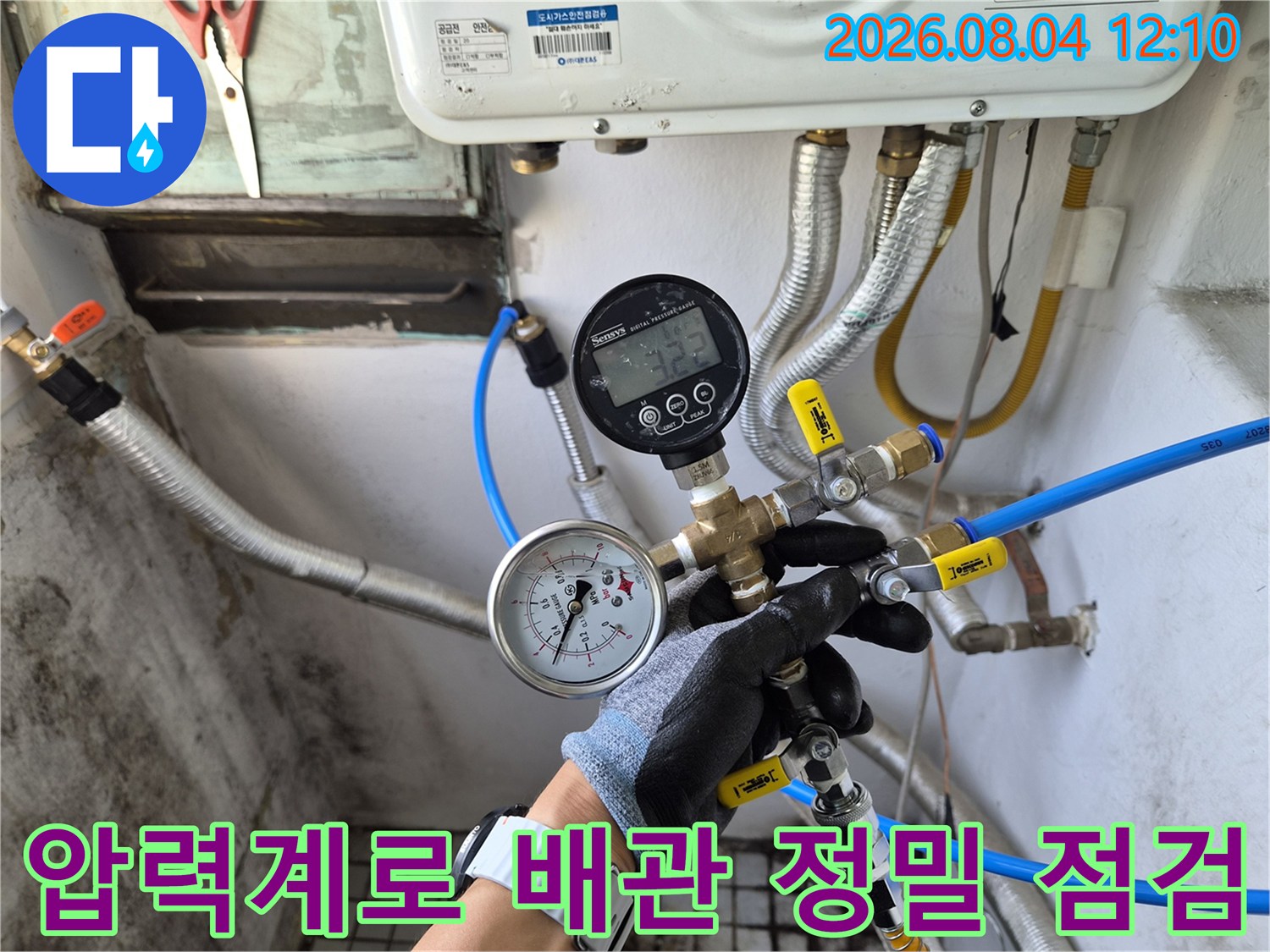 마감재를 제거하고 노출된 배관에 압력 게이지를 연결하여 누수 여부를 확인하는 모습