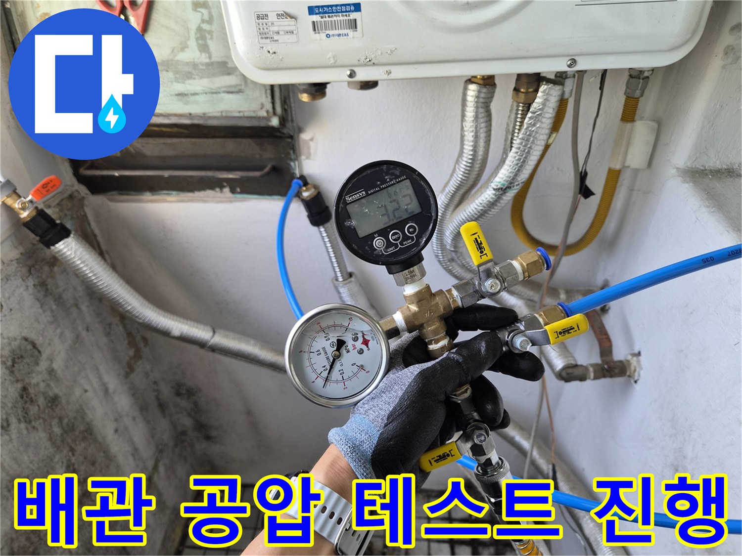 배관 연결 부위에 설치된 압력 측정 게이지와 파란색 호스