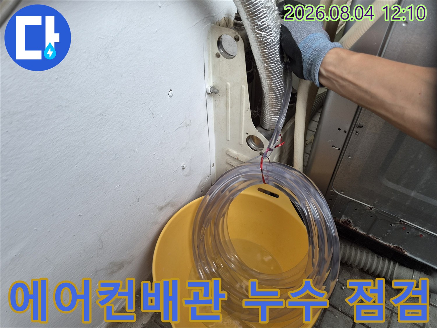 벽면을 뚫고 나온 에어컨 배관과 주변부의 누수 여부를 정밀하게 확인하는 작업 모습