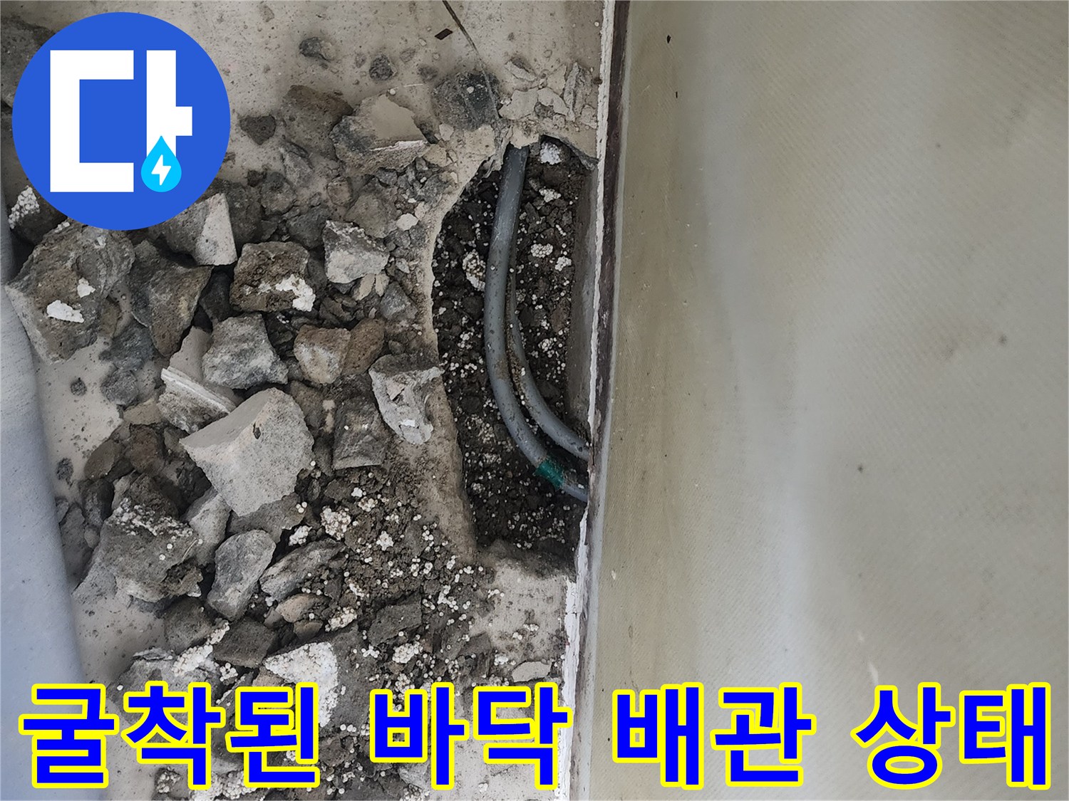 콘크리트 파쇄 후 드러난 손상된 수도 배관과 잔해물