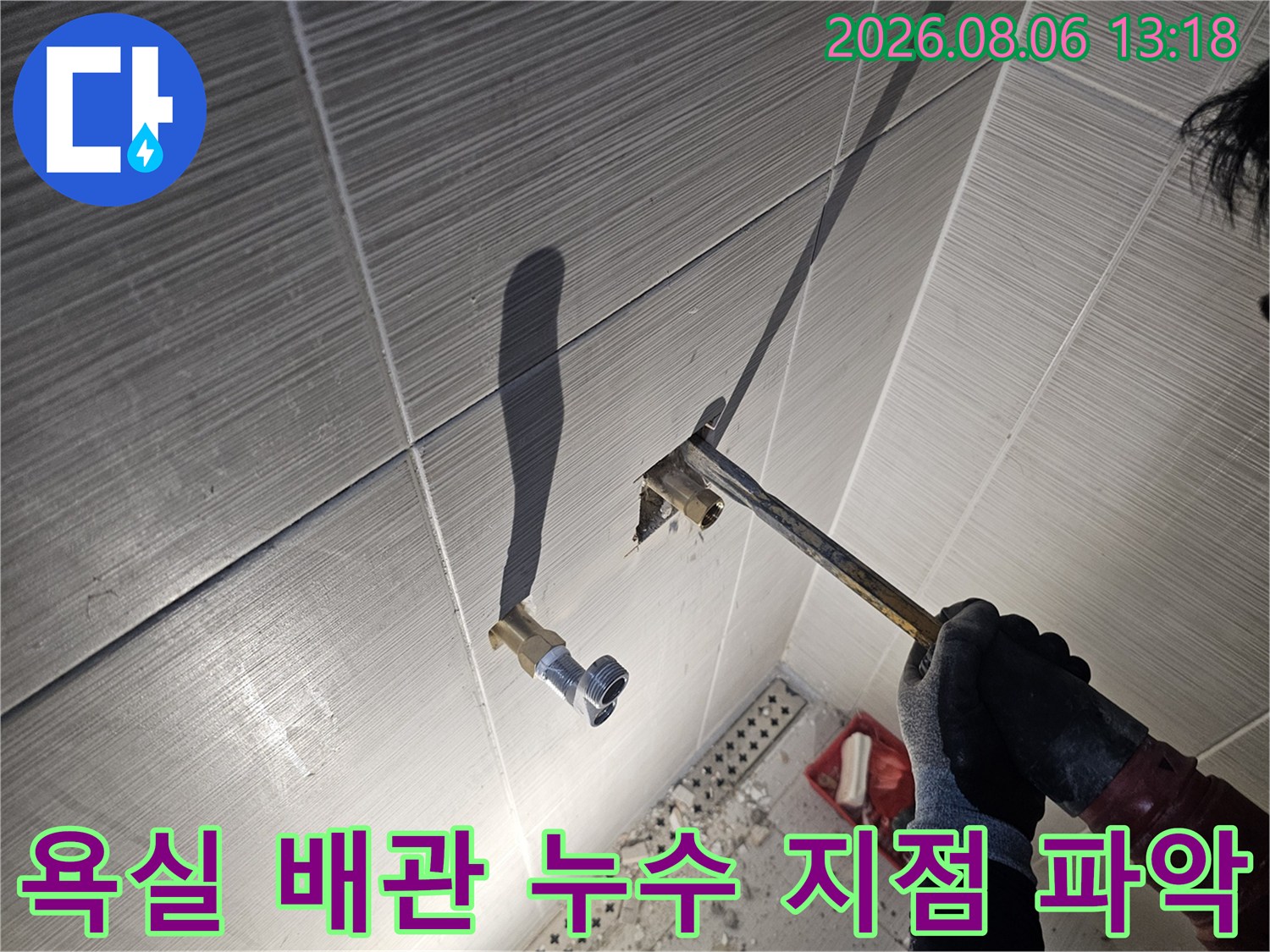 노출된 수전 연결부의 배관 상태를 세밀하게 점검하는 엔지니어의 손길