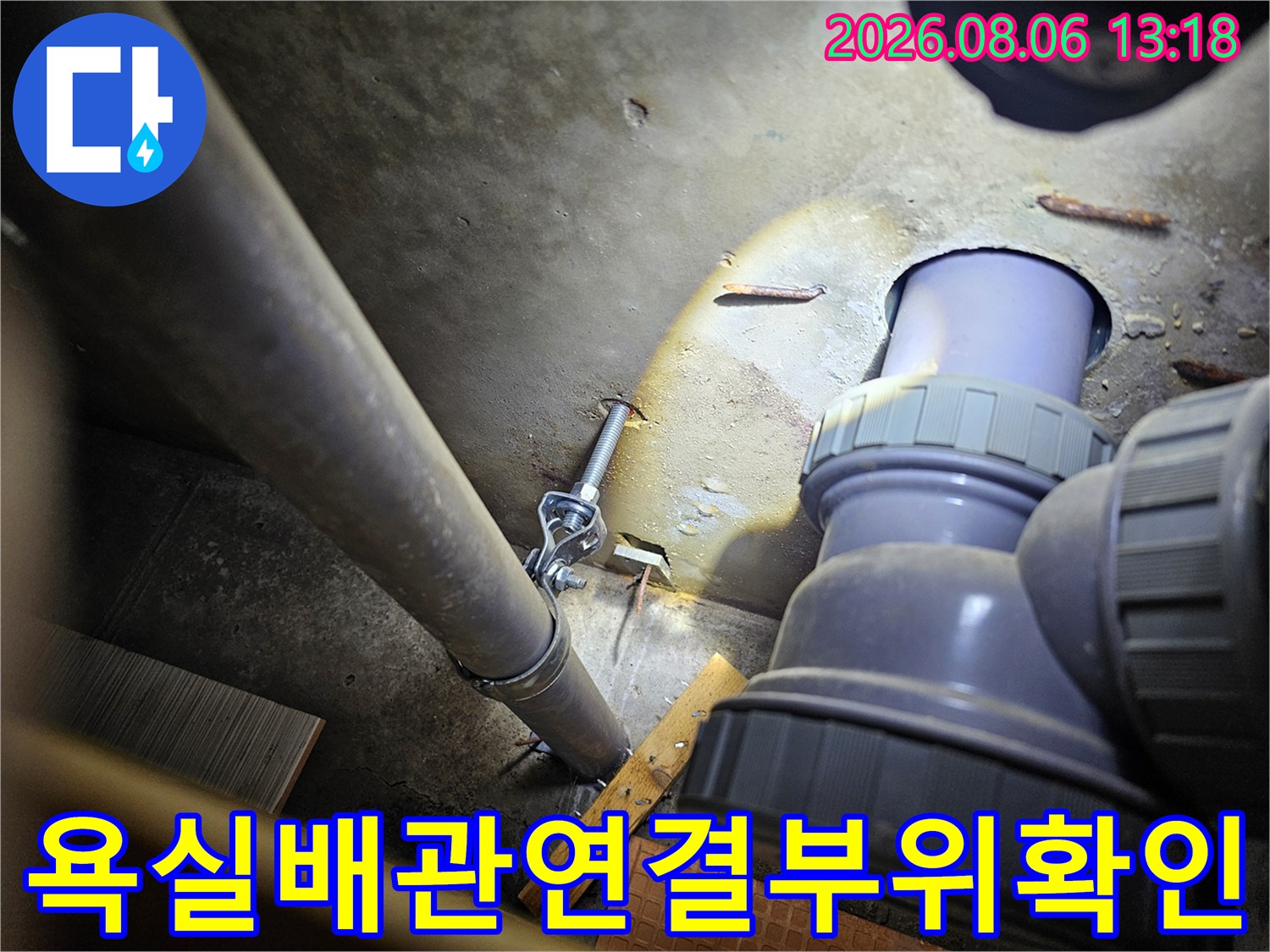 욕실 바닥면의 노출된 수전 연결 부위와 연장 소켓을 점검하는 모습
