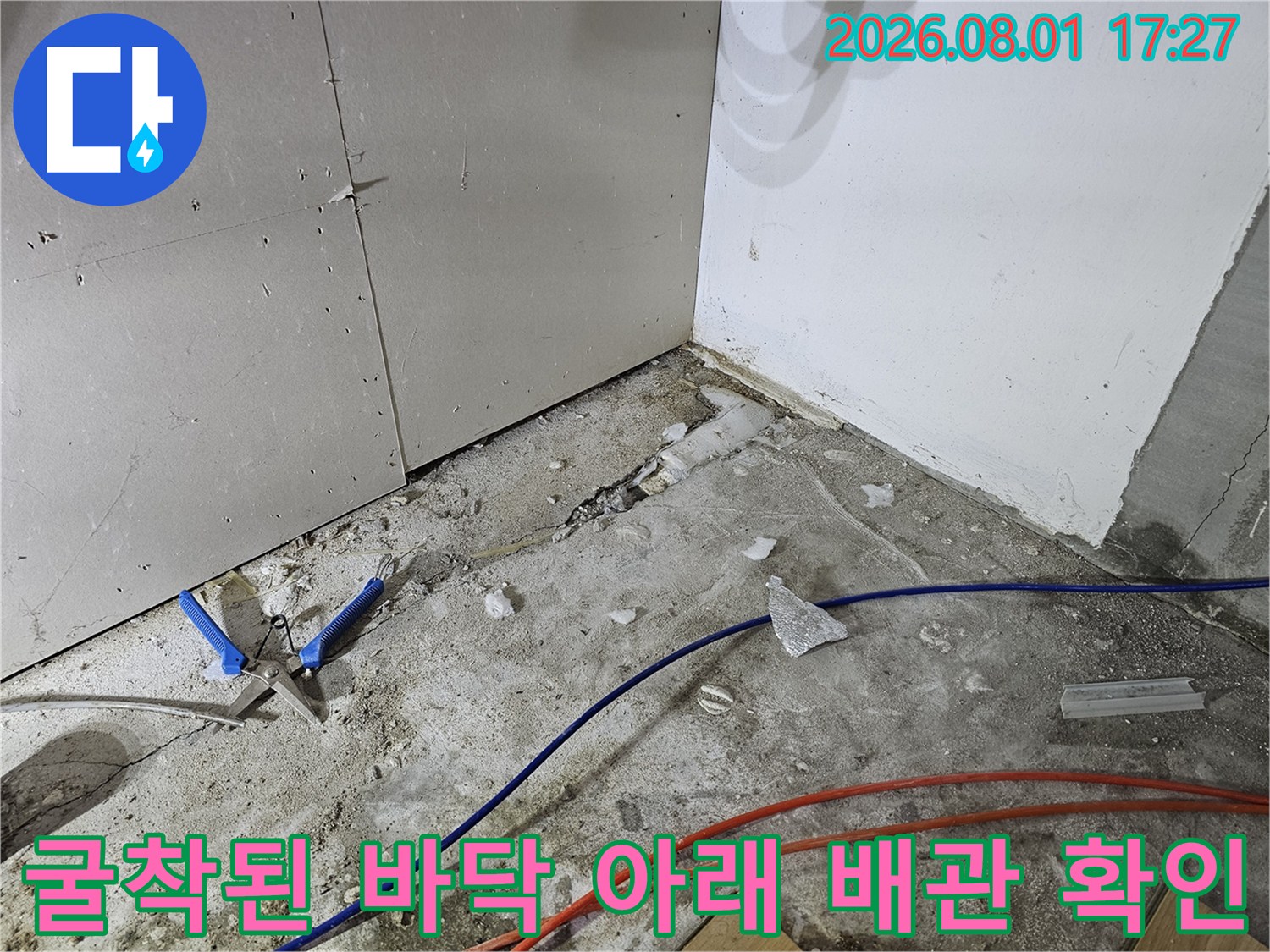 싱크대 하부 파쇄 구역에서 노출된 다수의 배관을 점검하는 장면