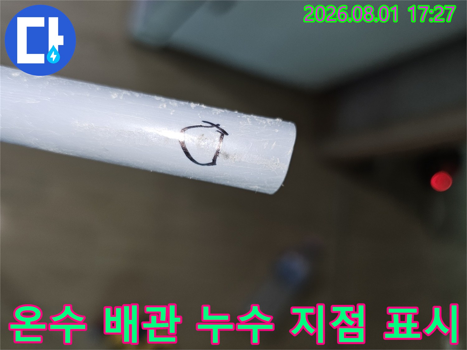 흰색 배관에 검은 매직으로 누수 위치를 표시한 모습