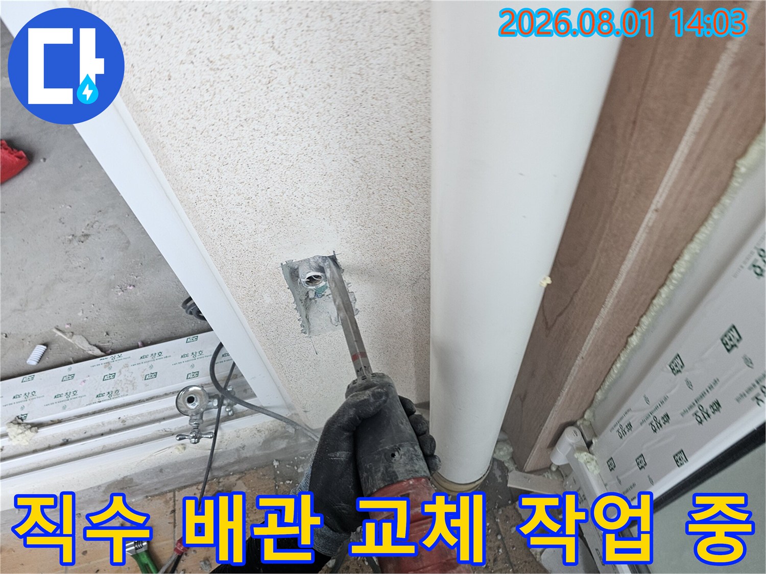 세탁실 벽면에서 나오는 직수 파이프의 연결 부위를 점검하며 수리하는 기술자의 모습