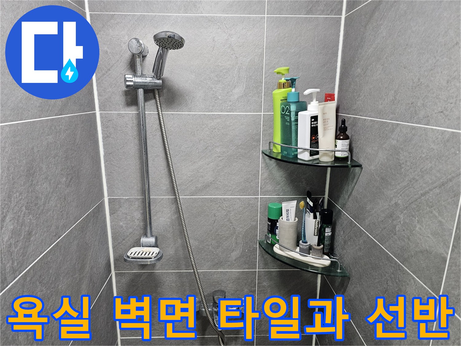 회색 타일 벽면에 설치된 투명 선반과 세정 용품들
