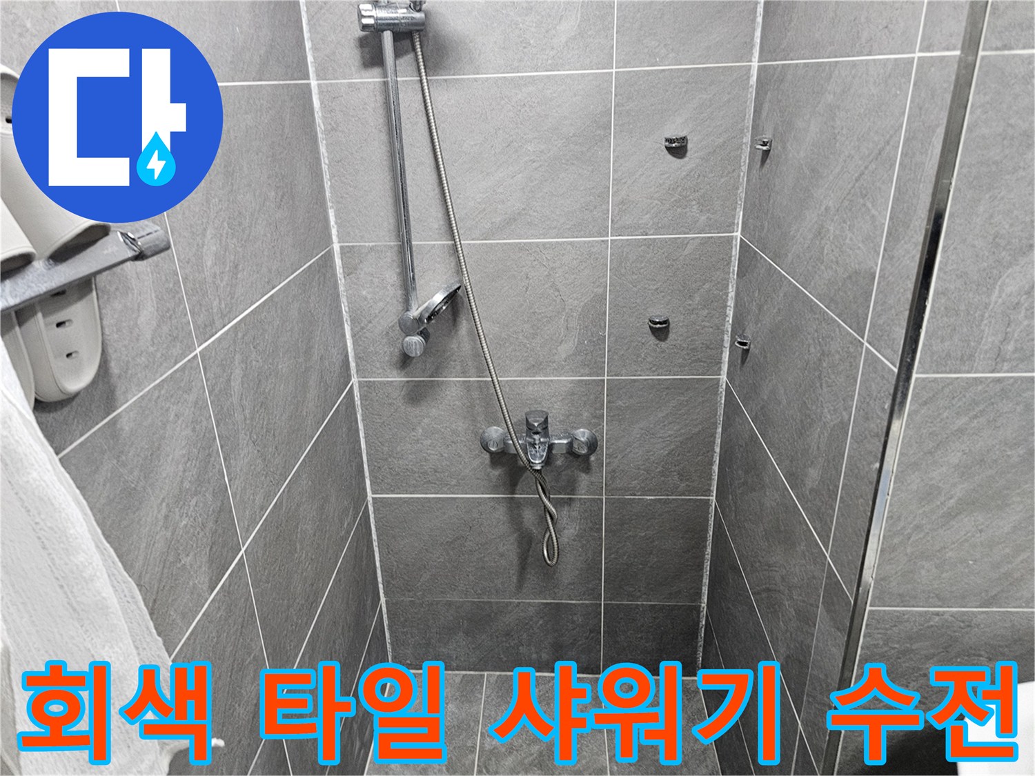 회색 타일로 마감된 욕실 내부의 샤워 수전과 벽면 모습입니다.