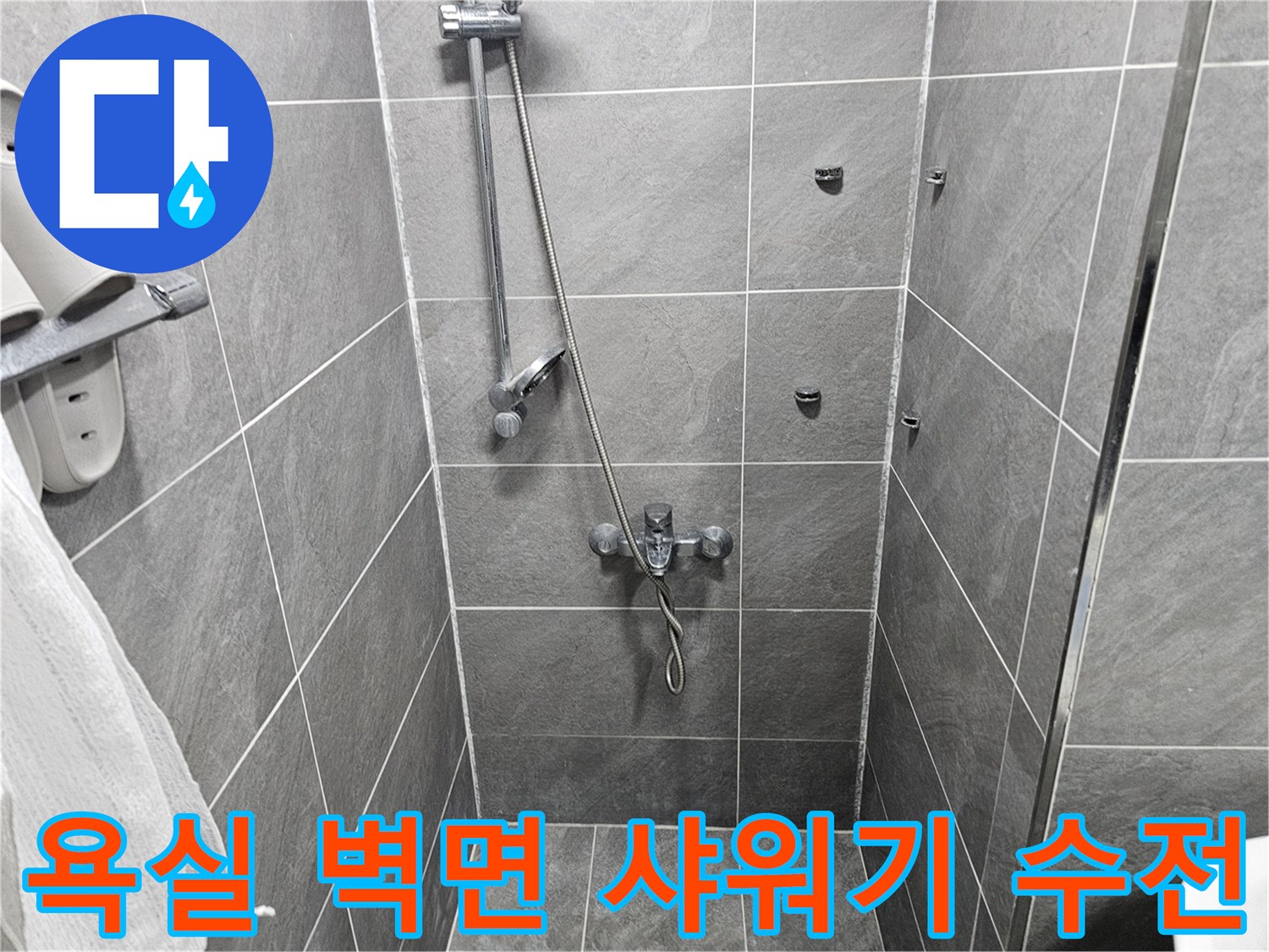 회색 타일로 마감된 욕실 내부의 샤워기 수전 부위