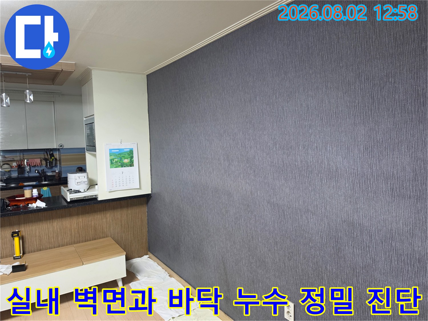 회색 벽지 공간에서 보양재 위로 진행되는 꼼꼼한 누수 추적 작업