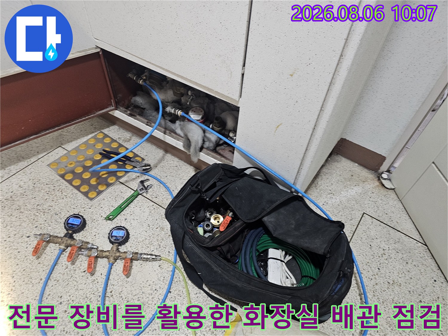 파란색 호스와 압력계가 연결된 상태의 화장실 천장 내부 배관 모습