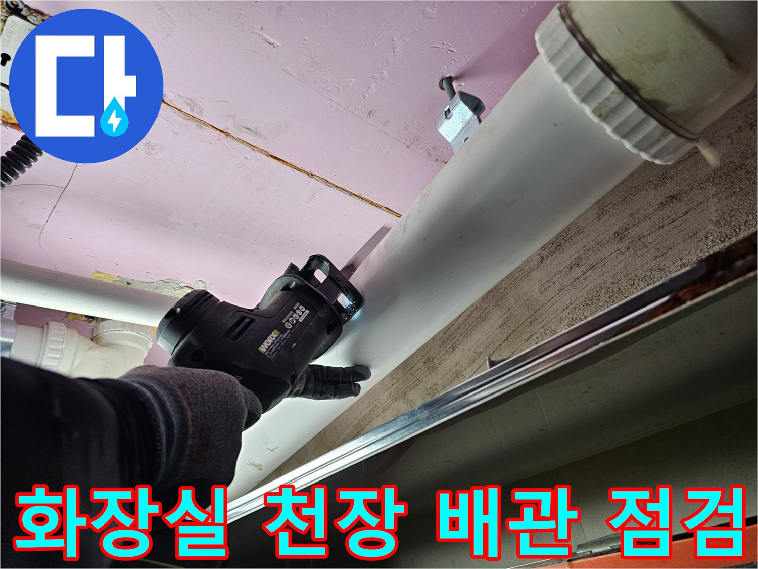 아파트 화장실 천장 내부의 흰색 배관과 점검 중인 장비 모습입니다.