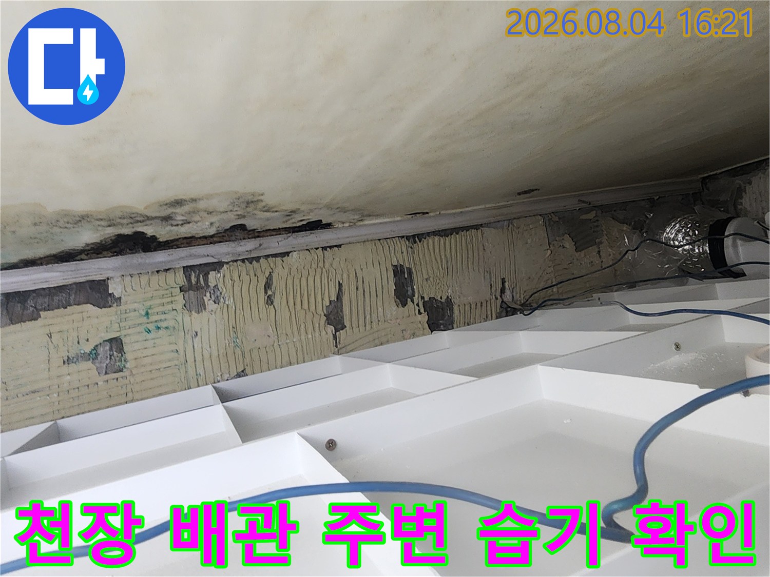 배관과 천장 구조물 사이의 누수 증거를 포착한 현장 사진