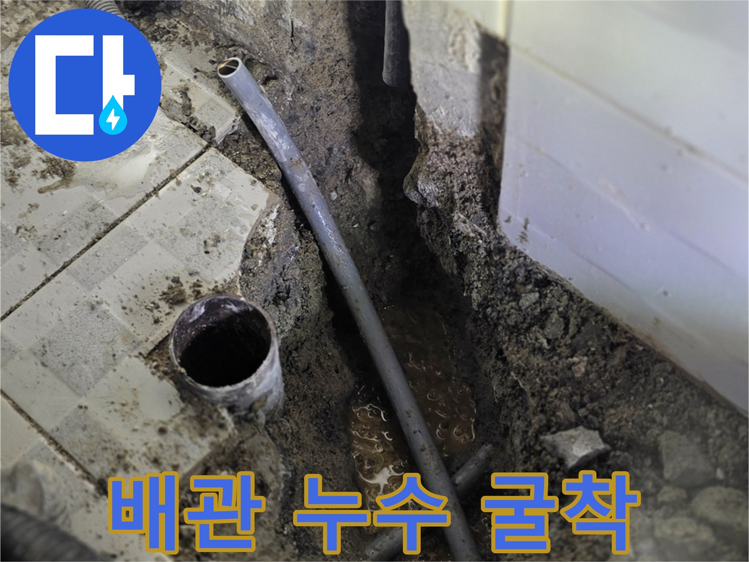 타일 아래 노출된 파손된 배관과 흙더미 현장 사진