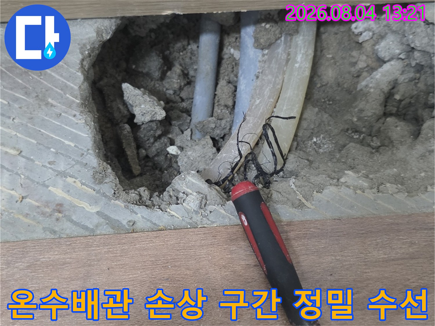 파손된 온수배관과 탐지 장비가 결합되어 작업 중인 모습