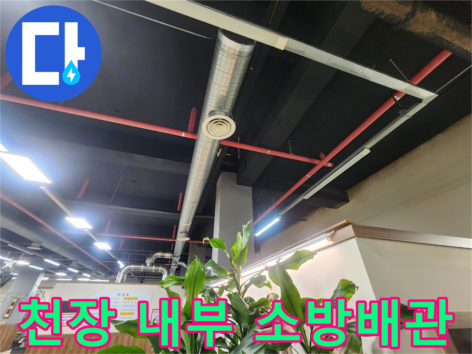 검은색 천장 구조물에 설치된 붉은색 소방 배관과 환기 시설